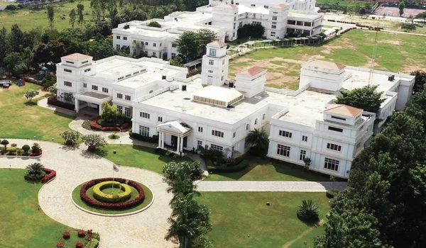 Candor International School, Bangalore — white campus buildings, lawns and the circular entrance drive seen from above
