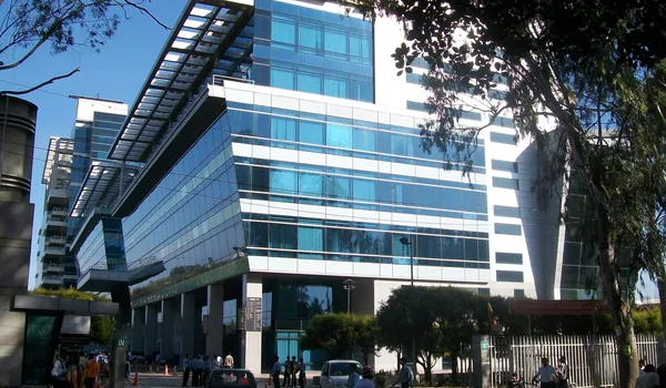 IBC Knowledge Park, Bangalore — glass and steel office towers seen from the street, with the gated entrance and pedestrians in front