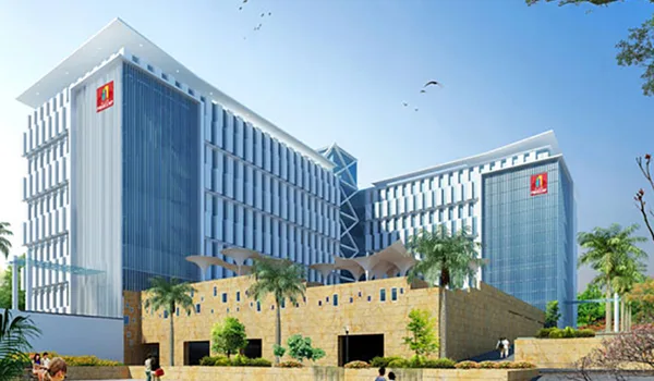 Primeco Towers, Bangalore — two blue-glass office blocks linked above a stone-clad landscaped podium